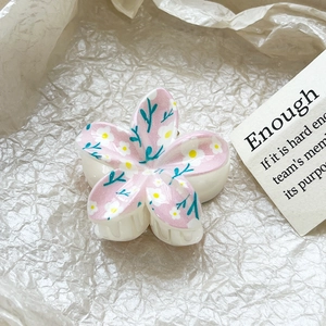 Close-up of floral hair claw clip featuring pink petal gradients and dainty leaf patterns