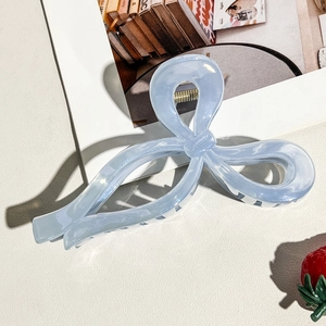 Detailed view of light blue pearlescent marble bow hair claw clip with golden spring