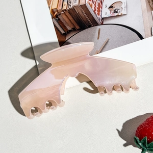 Macro detail of a large pearlescent pink claw clip with marble texture and strong grip