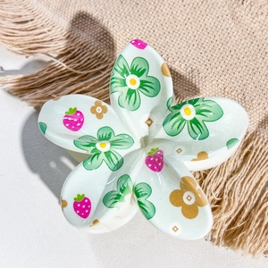 Close-up of plumeria hair claw clip with floral and strawberry UV print on linen
