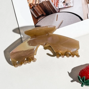 Macro detail of large amber jelly bow claw clip with smooth polished resin finish