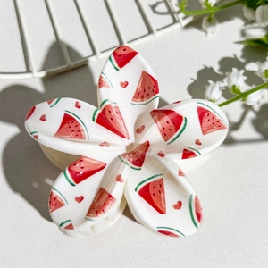 Detail of floral hair claw clip with watermelon print on glossy white acetate finish