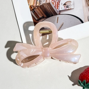 Detail of large pink ribbon hair claw clip showing a strong gold metal spring and smooth finish