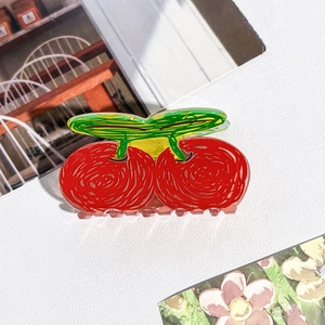 Vue détaillée d'une pince à cheveux cerise mignonne en acrylique rouge et vert pour femmes