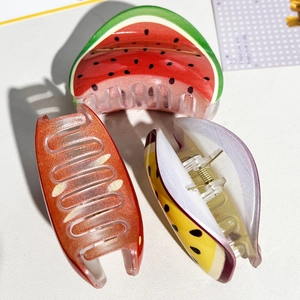 Détail de pinces à cheveux aux motifs de fruits avec ressort métallique sur fond blanc