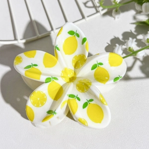 Detailed view of flower hair claw clip with yellow lemon and green leaf UV prints