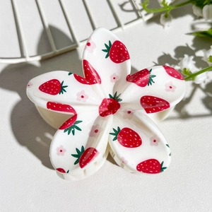 Detailed macro view of plumeria hair claw clip with sweet strawberry print pattern