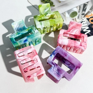 Set of five floral marble pattern hair claw clips in various pastel colors on a white surface