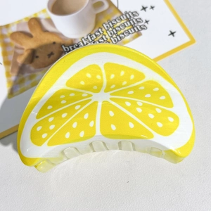 Vue détaillée d'une pince à cheveux en forme de citron avec motifs d'agrumes vifs