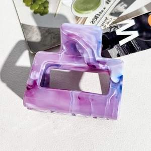 Detailed macro shot of rectangular marble pattern hair claw clip in purple and blue