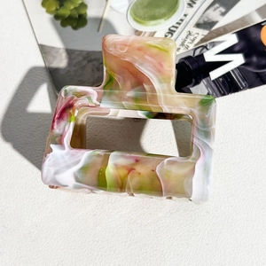Detail of square marble hair claw clip with pink and green watercolor texture