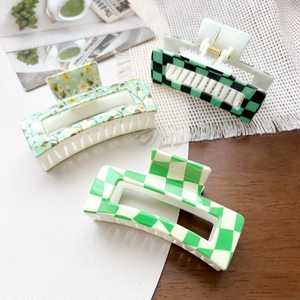 Three-piece set of checkerboard hair claws showing floral and grid patterns