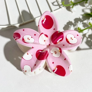 Detail of pink flower hair claw with apple print and white shark clip teeth