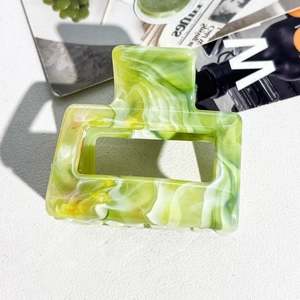 Detail of square cutout claw clip with green marble texture and aesthetic design