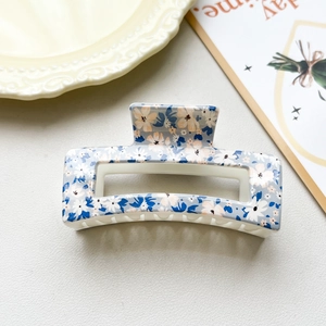 Close-up of a blue floral rectangle hair claw clip with non-slip teeth for secure styling