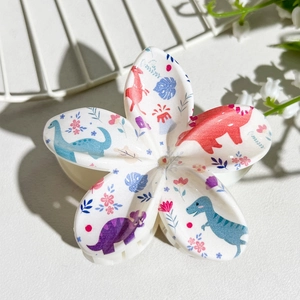 Detail view of flower-shaped hair claw clip with cute cartoon dinosaur UV printing
