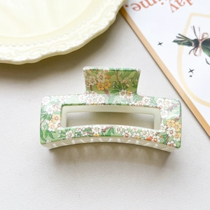 Detail of green floral checkered hair claw clip with 8.5cm hollow rectangular design