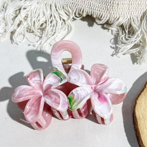 Detail view of the floral marble hair claw clip with pink resin petals and gold spring