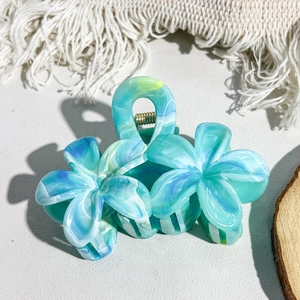 Macro shot of marble textured floral hair claw clip with golden metal spring detail