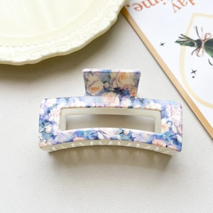 Detail of 8.5cm rectangular hair claw clip with blue and pink floral pattern finish