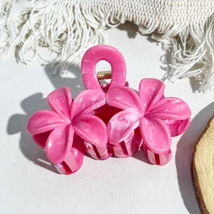 Close-up of pink marble pattern flower hair claw clip with golden metal spring detail