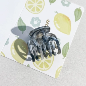 Macro view of the grey marble pattern and polished texture on the small hair claw clip