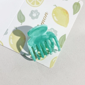Detail of mint green marble pattern acetate hair claw clip with seven sturdy teeth