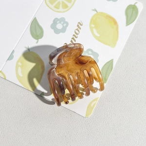 Detail of a 5cm square marble resin hair claw clip with amber tortoise shell pattern