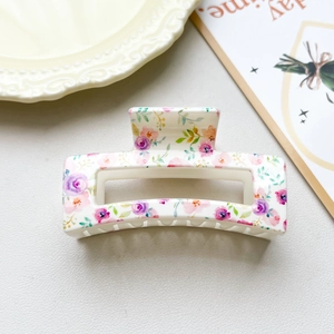 Detail view of large square hair claw clip with purple and pink floral patterns