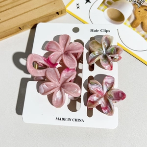 Détail de quatre pinces à cheveux florales avec texture marbrée sur carte