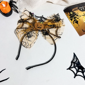 Detail of Halloween headband with orange glitter pumpkin and black spider web bow décor