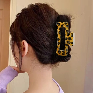 Halloween pumpkin pattern large square hair claw clip worn on model's back bun