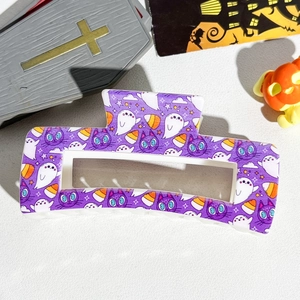 Detail of purple Halloween hair claw with spooky ghost and black cat prints on white base