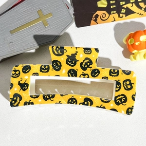 Detail of 8.5cm square Halloween claw clip with yellow pumpkin and spider web UV print