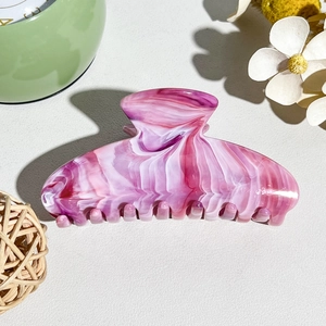Detailed macro shot of the pink marble textured hair claw clip on an elegant background
