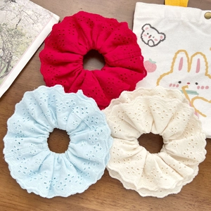 Three-piece lace scrunchie set in red, blue and beige on a wooden background
