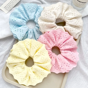 Detailed close-up of eyelet embroidery lace hair scrunchies in pastel colors