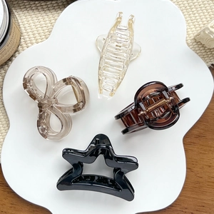 Lot de quatre pinces à cheveux minimalistes avec motifs étoile et papillon sur plateau