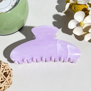 Detail of light purple acetate hair claw with white marble pattern and smooth teeth