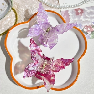 Detail of butterfly hair claws with marble texture in purple and magenta colors