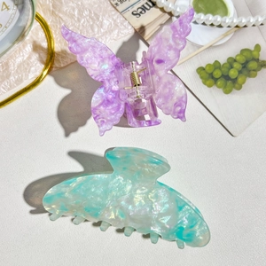 Detail of iridescent acetate hair claws including purple butterfly and mint green shark clips