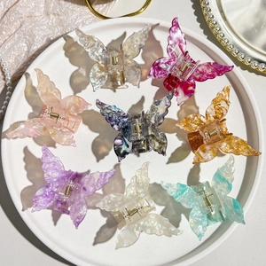 Detail of 8 butterfly hair claws featuring iridescent acetate textures and golden springs
