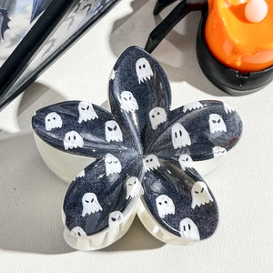 Close-up of Halloween flower claw clip with ghost print, spider and pumpkin decor