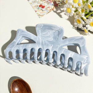 Dettaglio del grande fermaglio per capelli marmorizzato blu con accessori decorativi