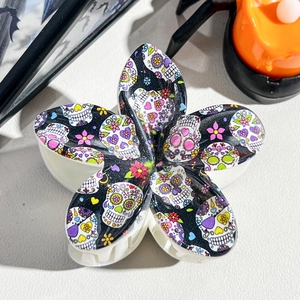 Detail view of flower hair claw with colorful Mexican sugar skull patterns for Halloween