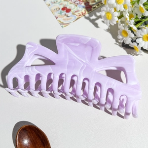 Dettaglio ravvicinato della grande pinza per capelli viola effetto marmo lucido