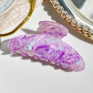 Macro detail of purple marble acetate hair claw clip with colorful iridescent shimmer