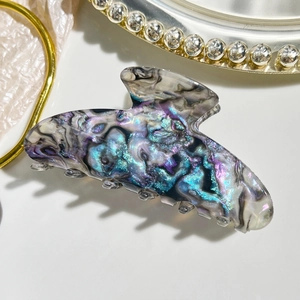 Macro detail of high-end iridescent acetate hair claw clip with colorful marble texture