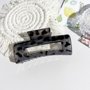 Detailed close-up of a leopard print claw clip with square hollow design on a white mat