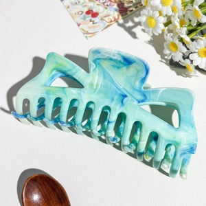 Dettaglio della grande pinza per capelli verde menta marmorizzata con design a triangolo